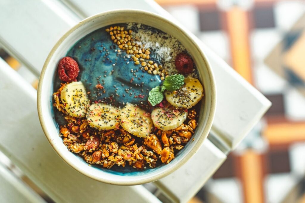 Färgstark smoothie bowl med banan, hallon, frön och granola