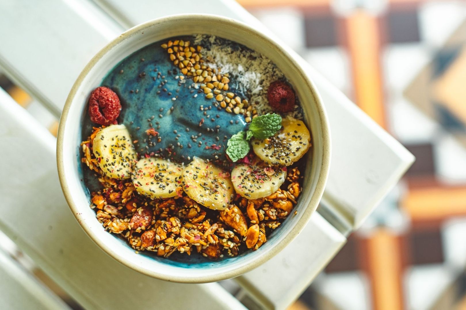 Färgstark smoothie bowl med banan, hallon, frön och granola